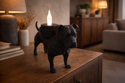 Zwarte Waxinelichthouder American Staffordshire Terrier met led-waxinelichtje op houten kast in warme industriële woonkamer.